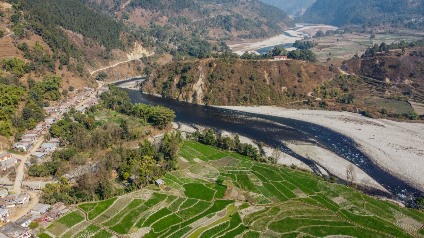 बूढीगण्डकी नदी किनारमा रहेको सबैभन्दा ठूला बस्तीमध्ये एक खहरे बजारको ड्रोनबाट खिचिएको तस्बिर । (तस्बिर : नवीन बराल/द थर्ड पोल)